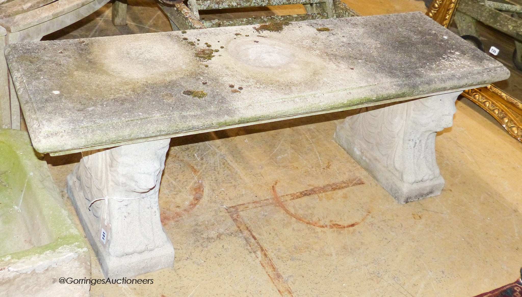 A reconstituted stone bench, with moulded rectangular top on stylised lion end supports, width 126cm, depth 41cm, height 44cm